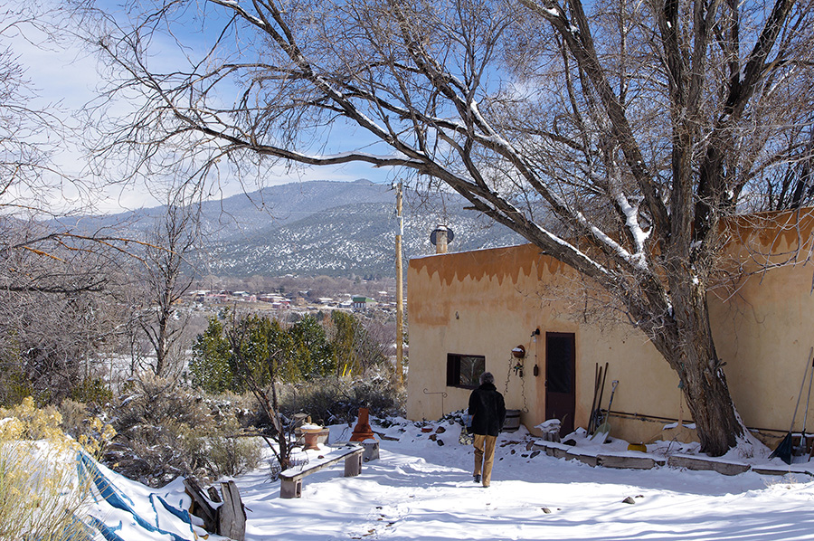 old adobe on a snowy hillside in Taos, NM