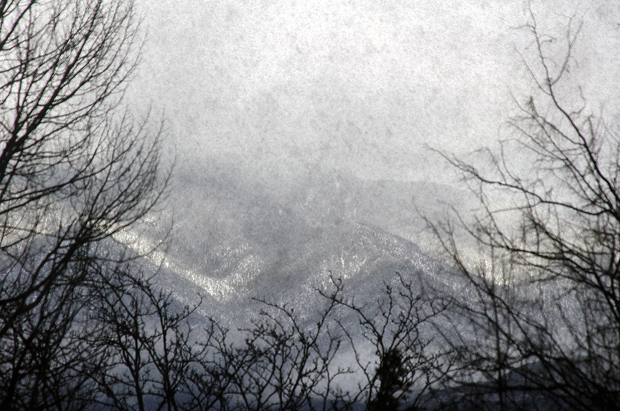 mountainside in snow through dirty window