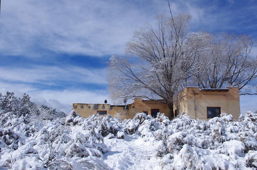 old adobe on a snowy hillside in Taos, NM