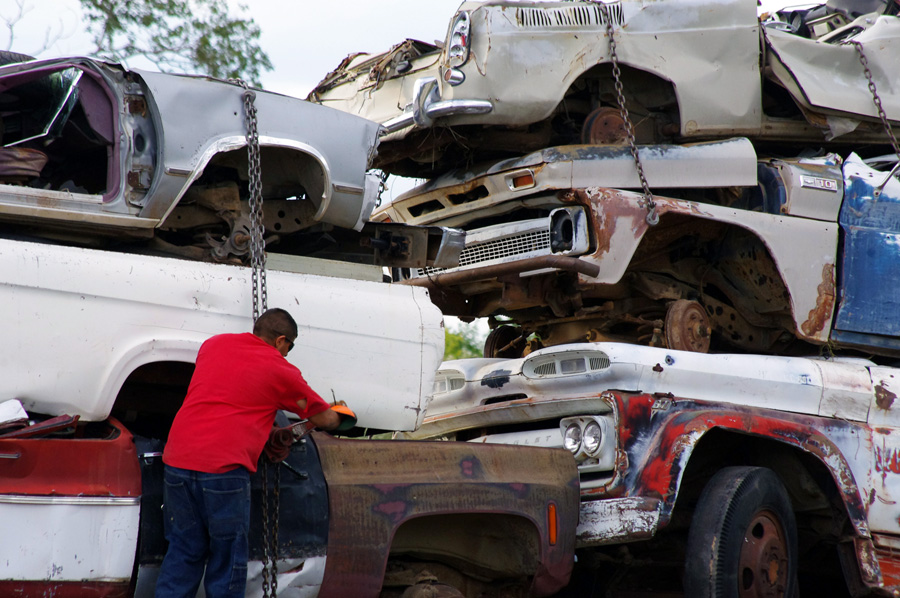 young dude tightening heavy load of junk on trailer